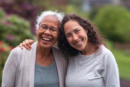 Grandmother and granddaughter hugging and smiling