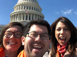 Three advocates cheering at the US capitol