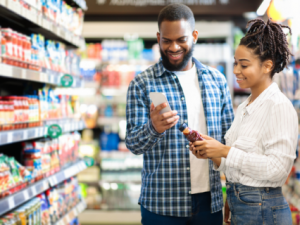 Two people reviewing food label in grocery store