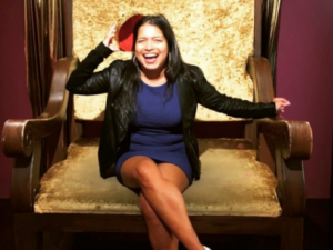 Isha smiling on a large golden throne