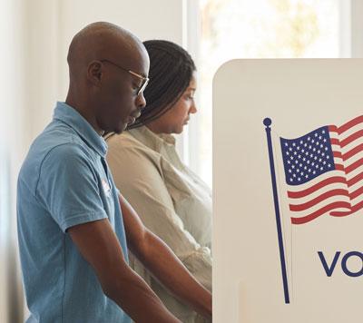 Two people voting at a voting booth