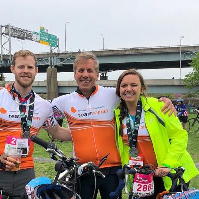 three cyclists taking a break while wearing Team Kidney uniforms