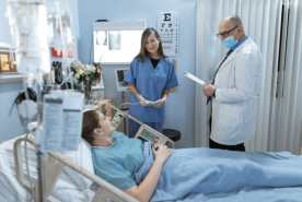 Person hospitalized with doctor and nurse in their room speaking