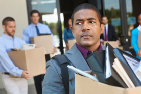 Group of sad professionals with boxes leaving office