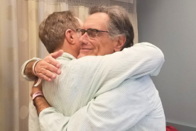 Michael Weissman (L) and Daniel Kushnik (R) hugging