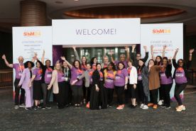 NKF Staff in front of SCM 24 welcome banner cheering
