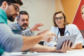 Healthcare professionals in a conference room reviewing data