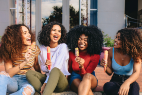 Four laughing friends with frozen treats