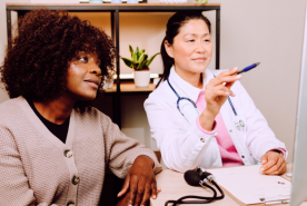 Doctor pointing at information with attentive patient nearby.