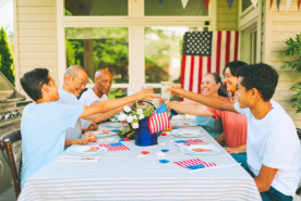 6 friends and family toasting around a 4th of July themed table