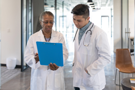 Two doctors speaking over patient chart