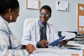 Smiling doctor speaking with happy patient