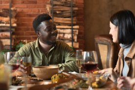 Two friends happily speaking over dinner