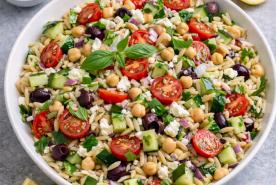 Greek salad with orzo, tomatoes, cucumbers, feta, chickpeas, and olives