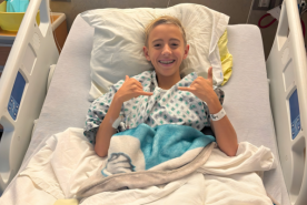 Rory giving cool hand gesture in hospital bed