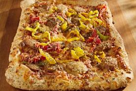 Homemade pizza with tomato sauce, cheese, onions, peppers, and ground beef topping