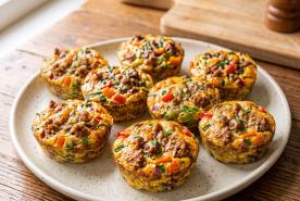 Savory egg cups with seasoned pork, colorful peppers, onions, and herbs