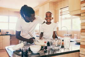 Parent and child cooking breakfast happily