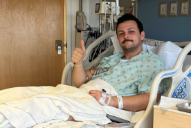 David in hospital bed giving thumbs up