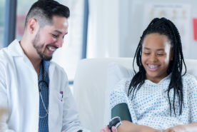 Younger patient looking at blood pressure with doctor