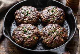 herby burger patties in a skillet