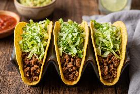 Tacos filled with seasoned ground beef and topped with shredded lettuce
