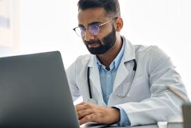 Doctor watching a educational video on a laptop