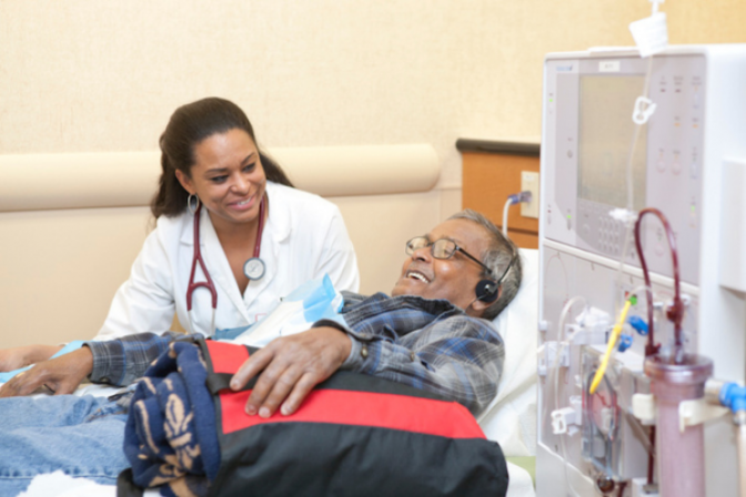 Healthcare professional laughing with patient on dialysis