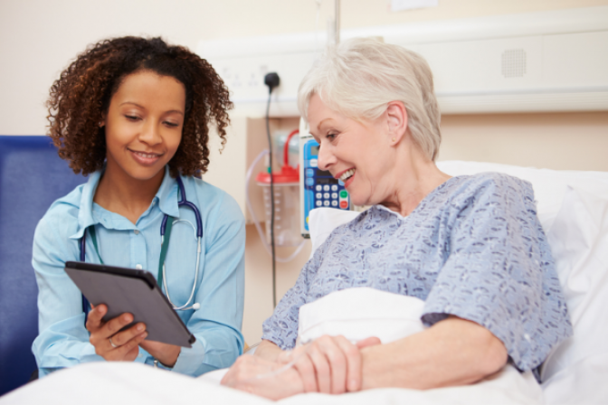 Profesional de atención médica de diálisis le muestra algo a un paciente en la tableta