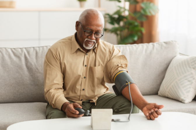 man on couch taking his own blood pressure measurements