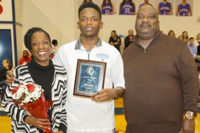 Lance Mason with a high school award in between his mother and father