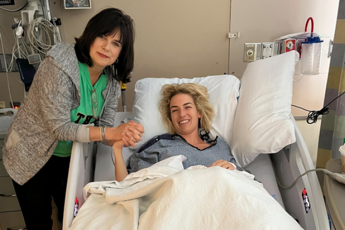 Megan Connolly (in hospital bed) and Margaret holding hands 