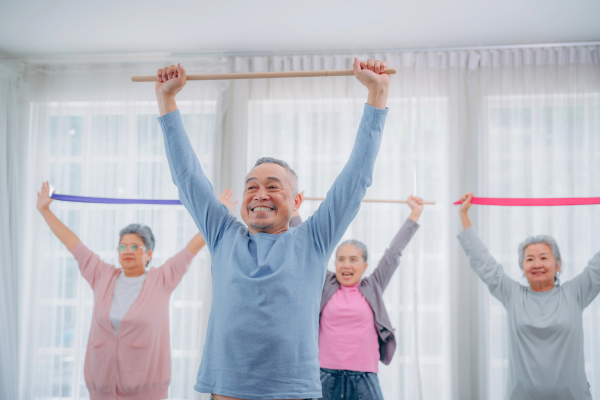 Four smiling people at resistance band exercise class 