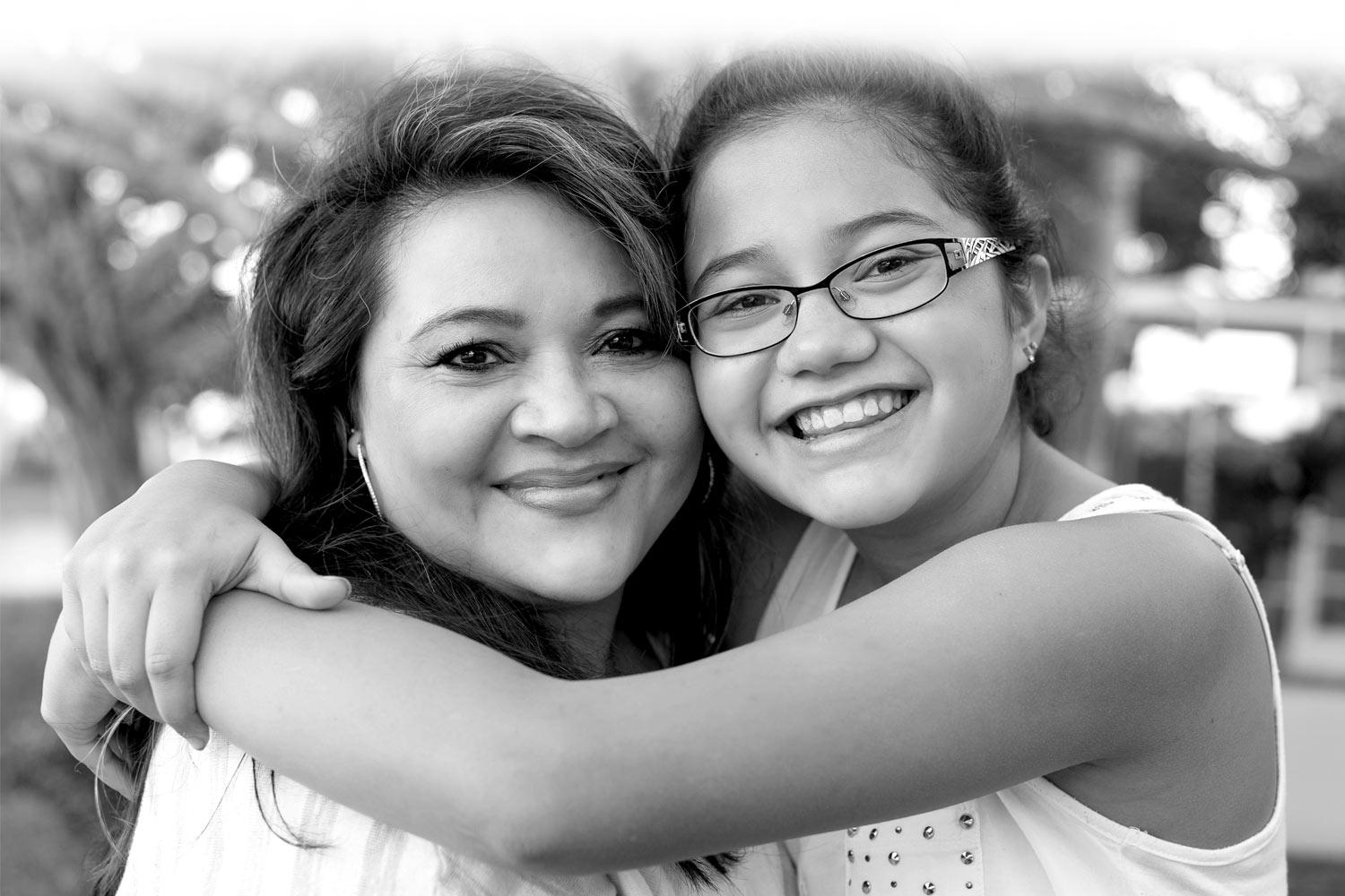 Mom and daughter hugging and smiling