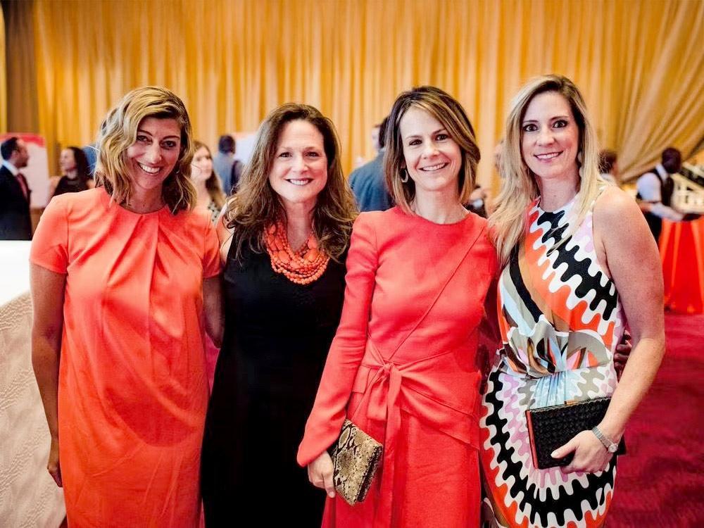 Four women in dresses posing together at an NKF Gala