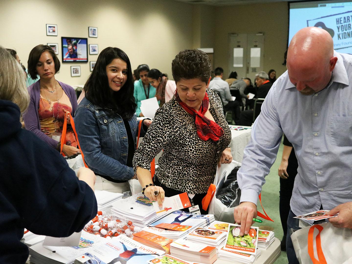 A group of people looking at kidney walk flyers