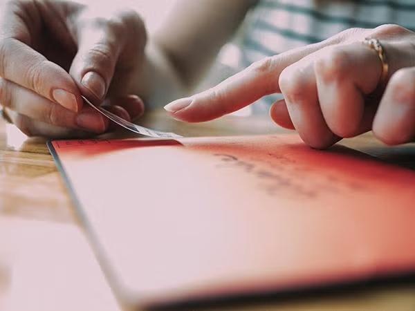 Woman placing a stamp on an envelope