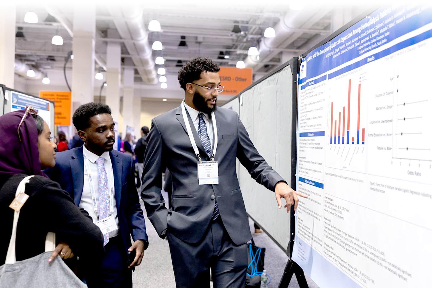 Two people looking at an abstract poster at SCM25