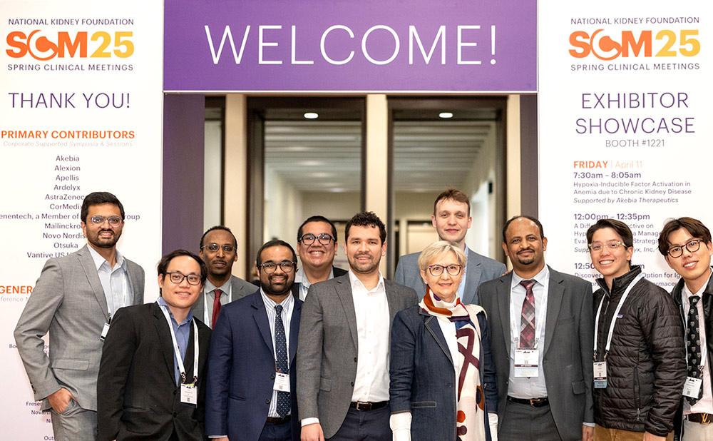 A group of healthcare professionals standing in front of a Welcome sign at SCM