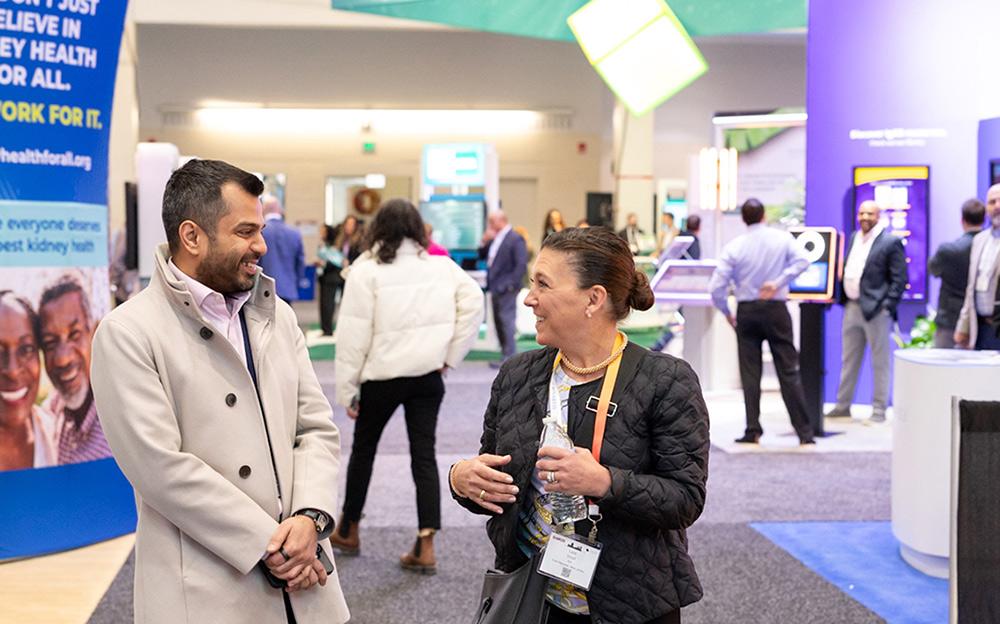 Two professionals smiling and chatting in SCM Expo Hall