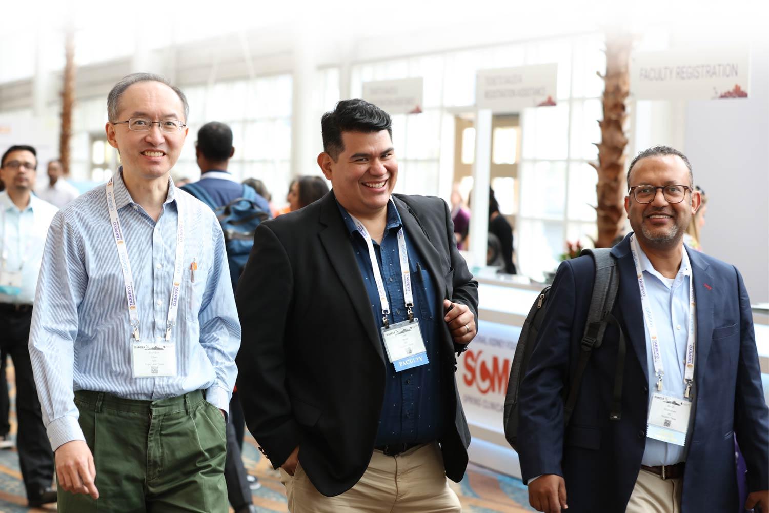 Group of male professionals walking in hallway and smiling at the camera