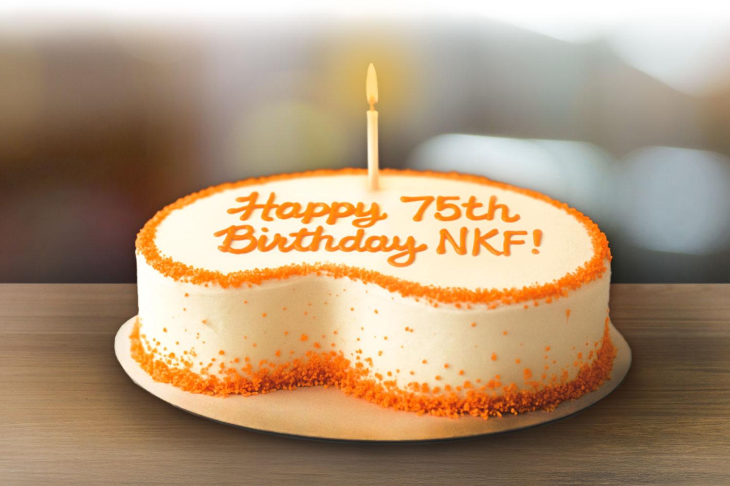 Kidney bean shaped birthday cake with Happy 75th Birthday NKF! in icing