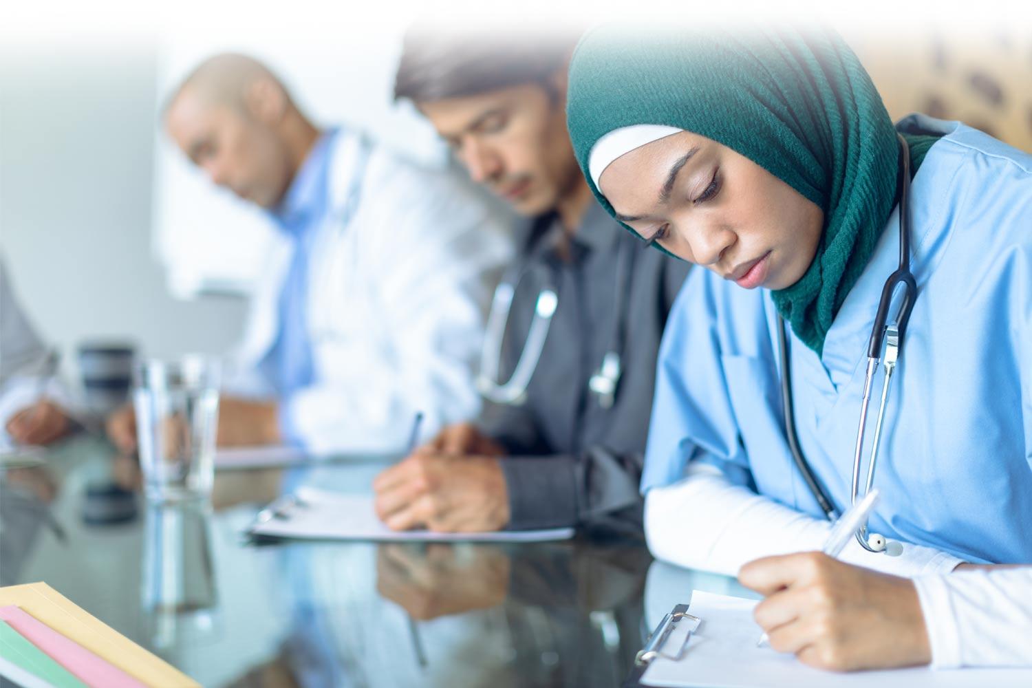 Group of healthcare professionals listening and taking notes