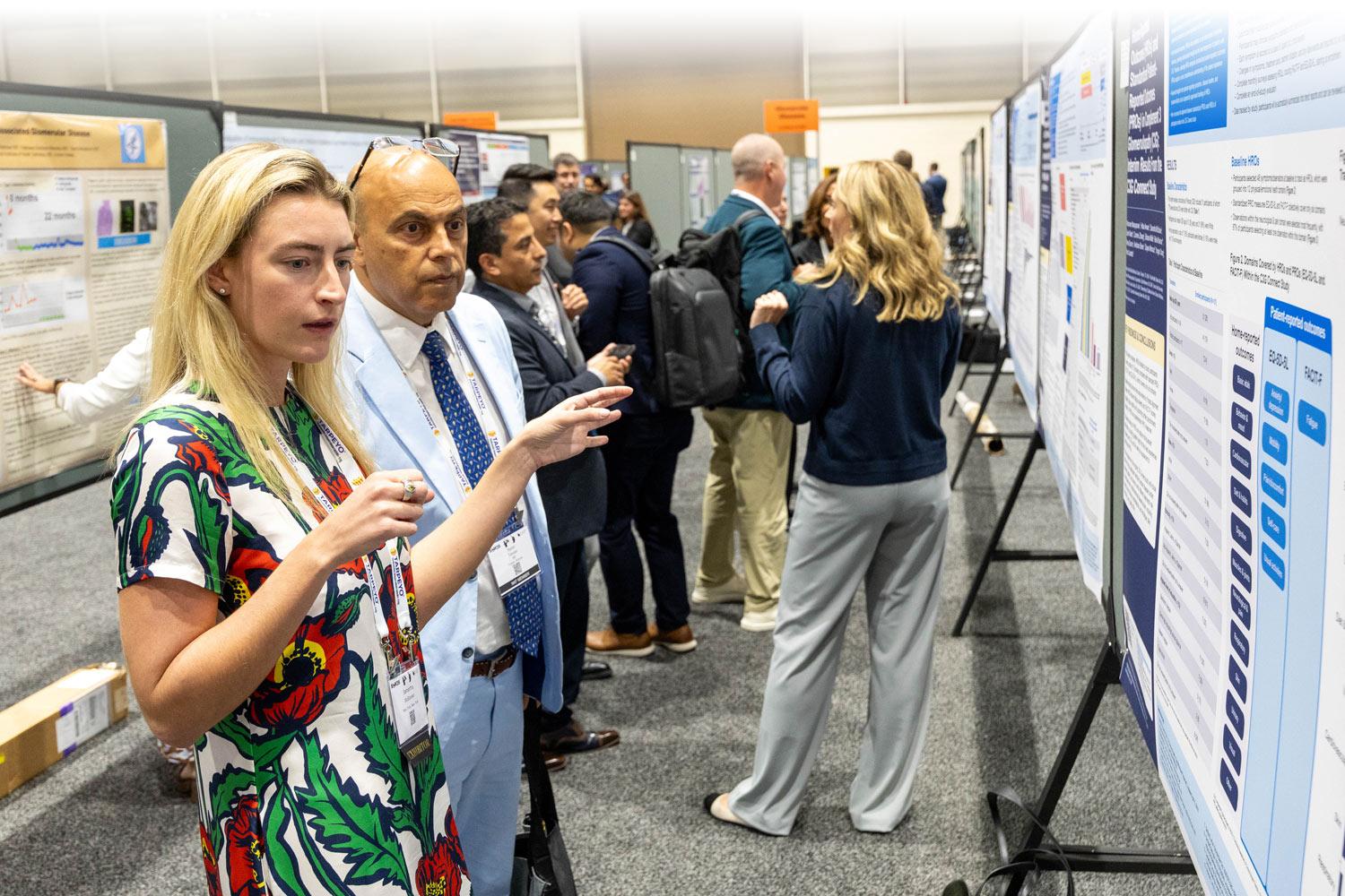 Attendees milling about and reading the abstract posters in the presentation hall