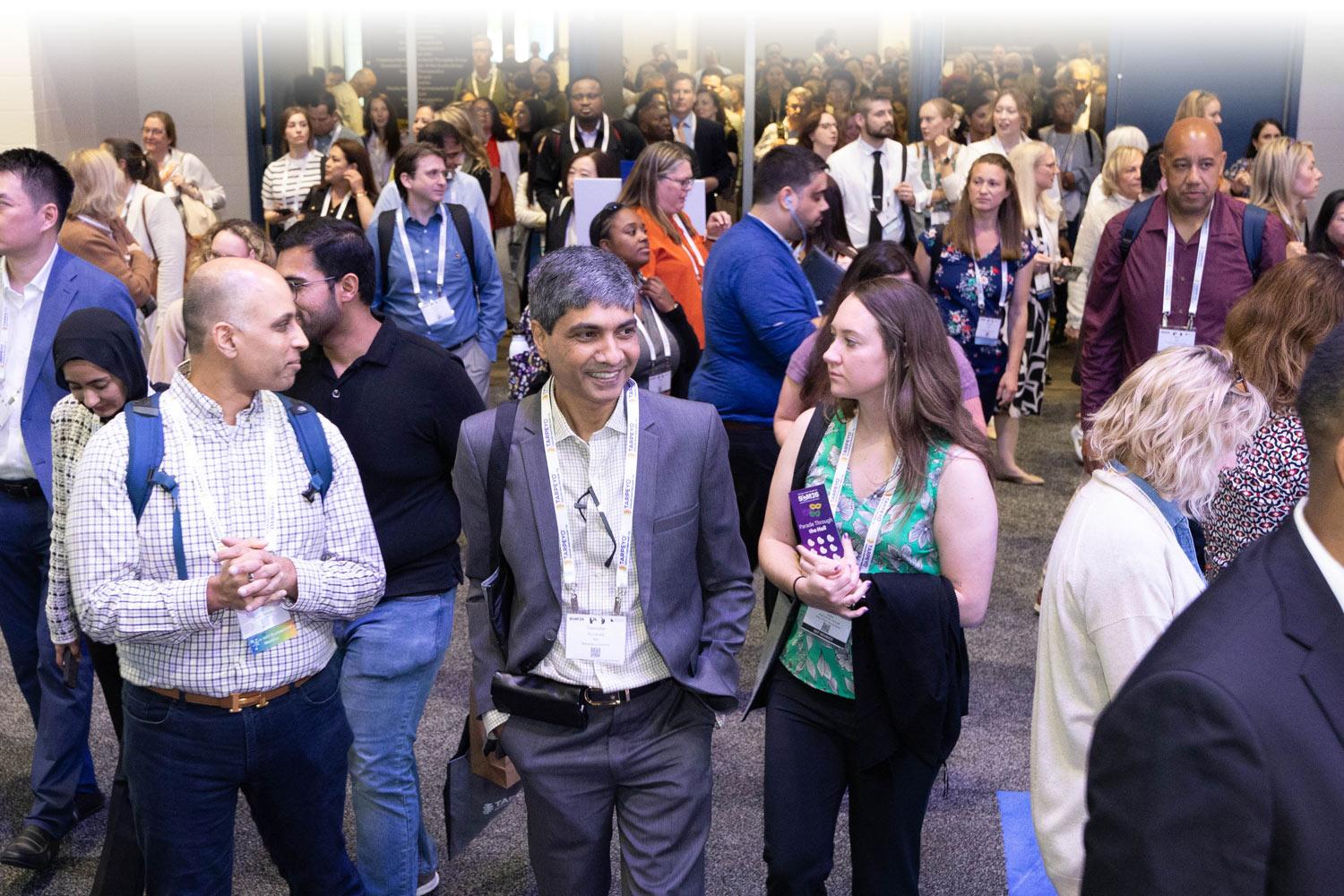 Attendees chatting and walking around in the exhibit hall