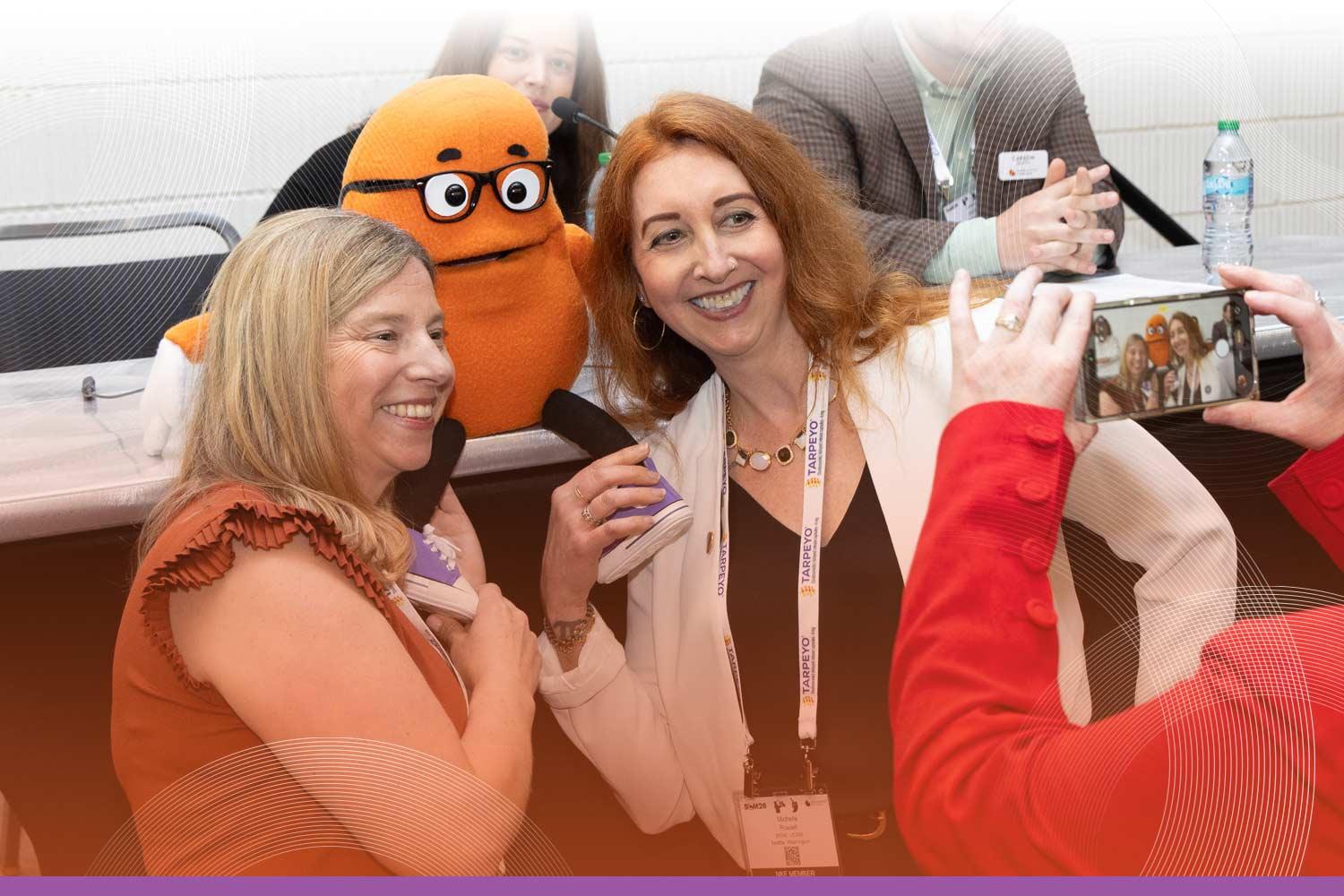 SCM attendees posing for a photo with the Kenny the Kidney mascot