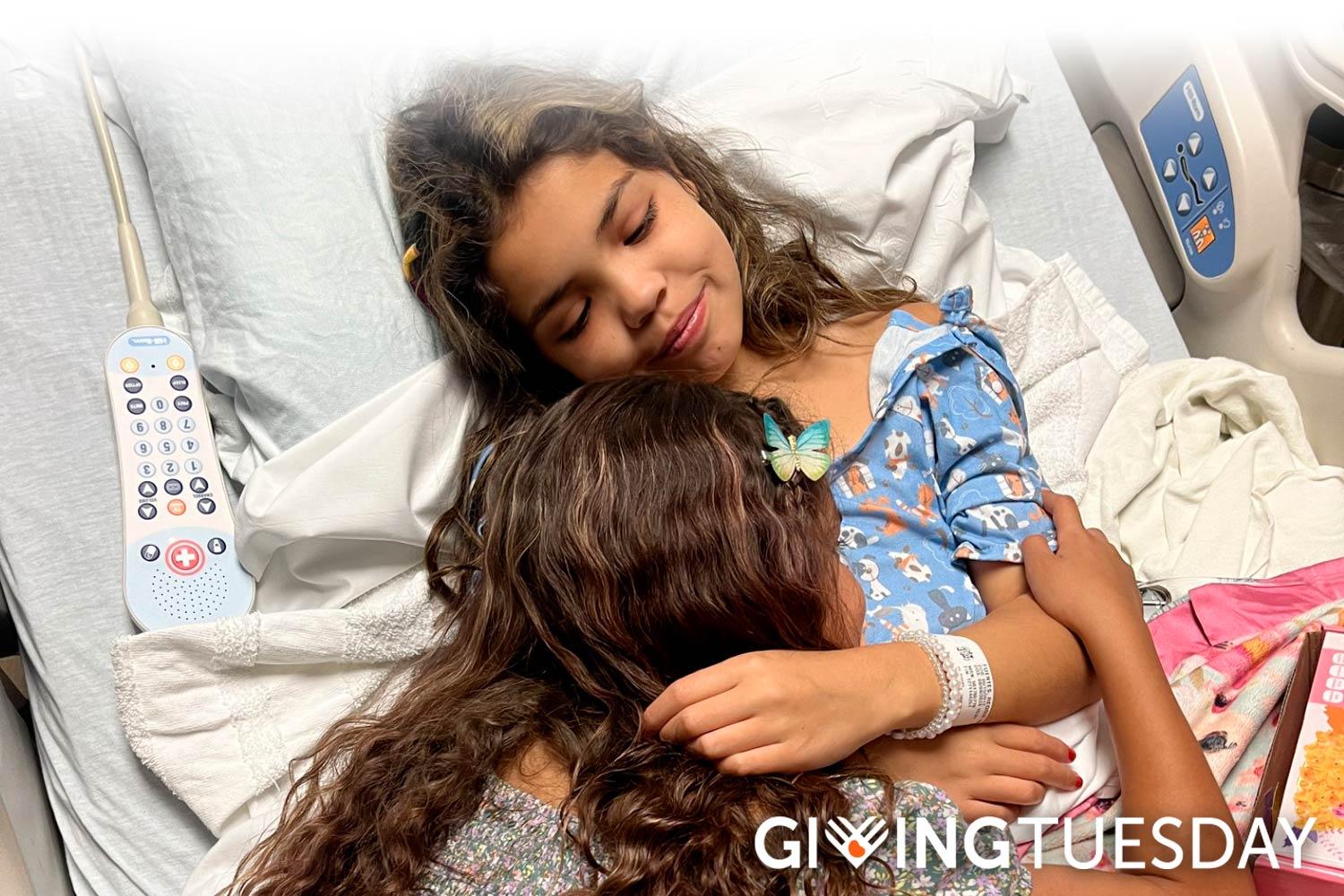 Reggie, a young kidney patient, being comforted by her sister in a hospital bed. Giving Tuesday logo.
