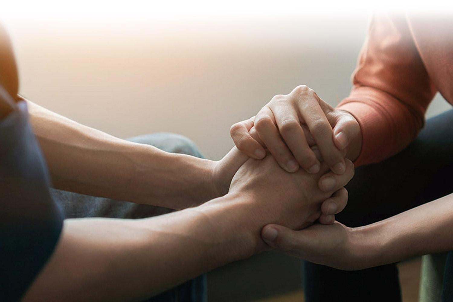Family members comforting each other by holding hands