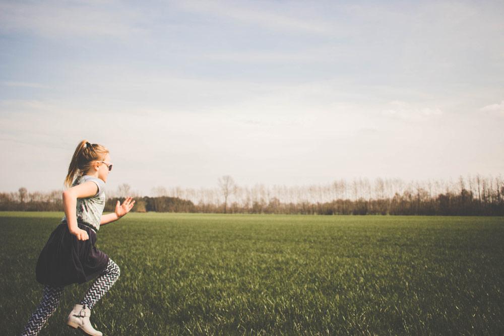 Kid running across a field