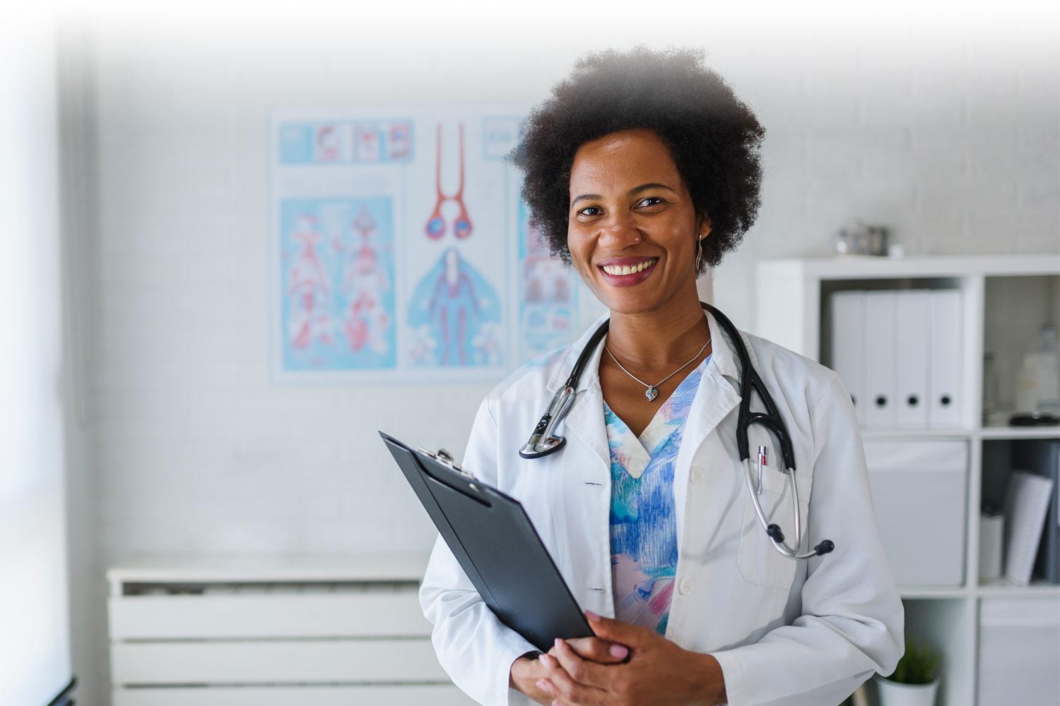 Healthcare Professional standing in her office with a clipboard, looking at camera